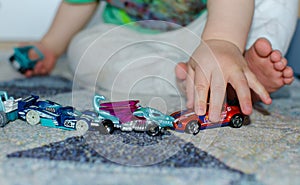 Child lining up cars on the floor at home