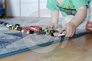 Child lining up toys on the floor at home