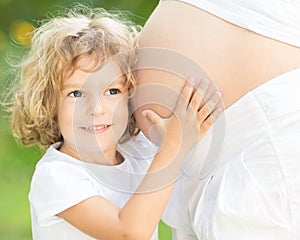 Child listen belly of pregnant woman