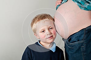 Child listening to pregnancy bump