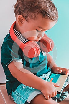 Child listening to videos with mobile phone and headset