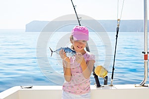 child little girl fishing in boat holding little tunny fish catch