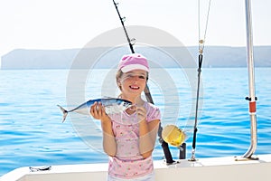 child little girl fishing in boat holding little tunny fish catch