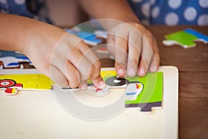 Child little girl hand trying to connect jigsaw puzzle piece