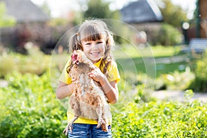 Child little girl with hen outdoor