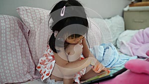 Child little girl playing game,eyes concentrate to mornitor in her bedroom.