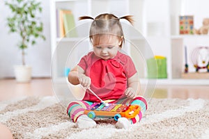 Child little girl plays a musical instrument photo