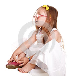 Child little girl tries to put on her shoes isolated