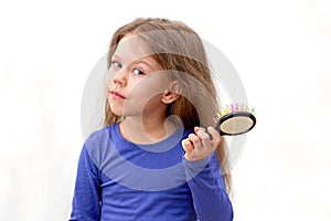 Child with long hair and hair brush with hair