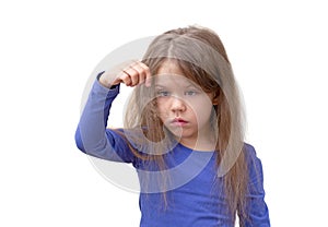 Child with long hair holding piece of hair pulling out