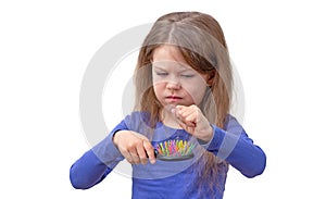 Child with long hair pulling out hair from brush