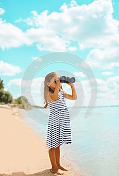 Child looking through binoculars in the expanse