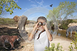 Child looking through binoculars on a safari