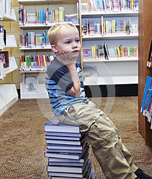 Child looking for a book on the shelf at the library