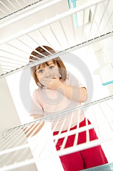 Child looking in empty fridge