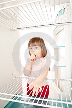 Child looking in empty fridge