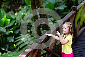 Child looking at flower in jungle