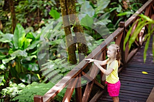 Child looking at flower in jungle