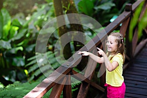 Child looking at flower in jungle