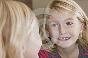 Child looking in mirror at missing front tooth