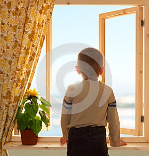 Child looking through open window