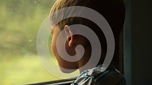 Child looking out the window of moving train