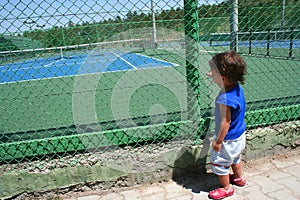 Child looking tennis court