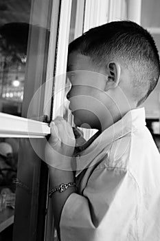 Child looking through a window, child longing