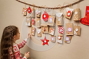 Child looks at the advent calendar. option DIY to wait for Christmas for kids