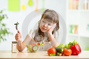 Child looks with disgust for food. photo