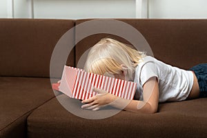 Child looks into an open gift box and searches for a gift. Frustrated child