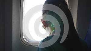 Child Looks in Window in Airplane