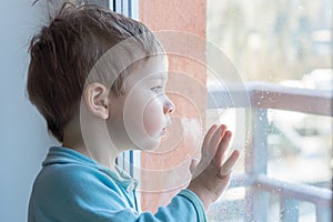 The child looks at the window in surprise