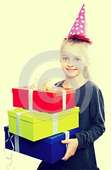 Child with a lot of gift boxes in hands on isolated background