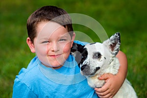 Child lovingly embraces his pet photo