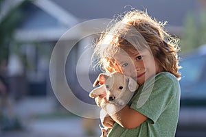 Child lovingly embraces his pet dog. Cute kids boy enjoying with her best friend dog. Positive emotions of children.