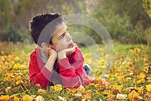 Child lying on the autumn ground
