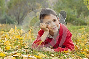 Child lying on the autumn ground