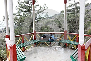 Child lying on bench in gazebo