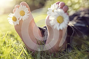 Child lying in meadow relaxing in summer sunshine