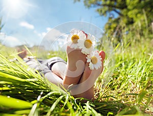 Child lying in meadow relaxing in summer sunshine photo