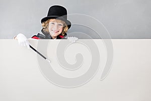 Child magician hiding behind banner blank