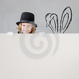 Child magician hiding behind banner blank