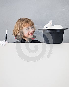 Child magician with rabbit holding banner blank