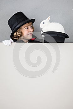 Child magician with rabbit holding banner blank