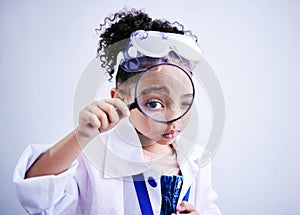 Child, magnifying glass and portrait of a scientist girl in studio with eye for scientific research. Face of a African