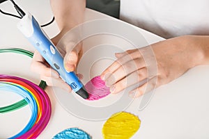 Child make Easter eggs by 3d pen plastic filaments.