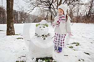 Child Make A Snowman In The Park At Winter Day