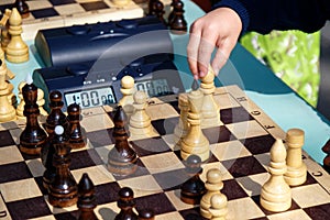 The child makes a move in a chess game.