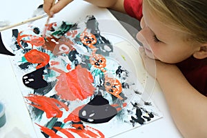 Child making abstract card for the  halloween. Funny crafts from paper. Halloween decor. The concept for Halloween. DIY. Children`